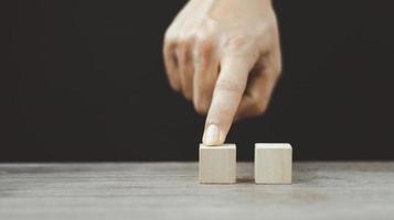 hand- regelen van hout blok stapelen net zo stap trap Aan houten tafel. bedrijf concept voor groei succes werkwijze. kopiëren ruimte foto