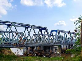 spoorweg brug, onder de groot bruin rivier, Doorzichtig blauw lucht foto
