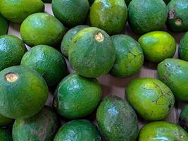 bundel van groen avocado's Bij de lokaal fruit markt. gezond en heerlijk vers fruit. deze fruit is vaak gebruikt in sappen foto