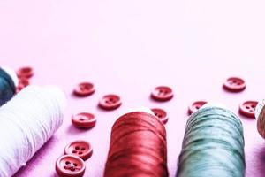 mooi structuur met veel van ronde rood toetsen voor naaien, handwerk en strengen van spoelen van draad. kopiëren ruimte. vlak leggen. roze, Purper achtergrond foto