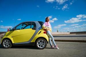 12.04.2019 Rusland heilige petersburg. een jong gelukkig vrouw staat door een slim voor twee auto tegen een blauw lucht met wolken foto