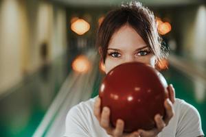 jong vrouw hebben pret in een bowling steeg foto