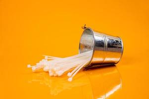 nylon- kabel banden in glas in pot in emmer Aan oranje achtergrond foto