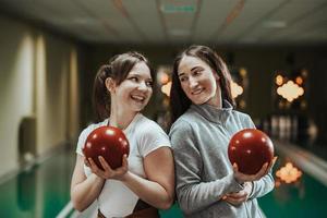 twee jong vrouw spelen bowling negen pin foto