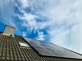 zonnepanelen die schone energie produceren op een dak van een woonhuis foto