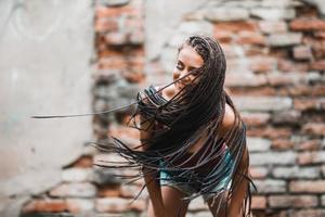 vrouw met lang afro gevlochten haar- hebben pret buitenshuis foto