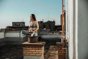 vrouw mediteren buitenshuis Aan een op het dak terras foto