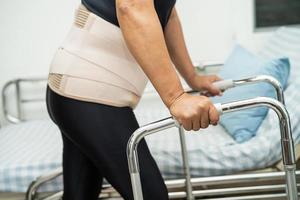 Aziatische dame patiënt pijn haar rug, taille en orthopedische lumbale met rollator. foto