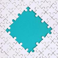framing in de het formulier van een ruit, gemaakt van een wit decoupeerzaag puzzel in de omgeving van de blauw ruimte foto