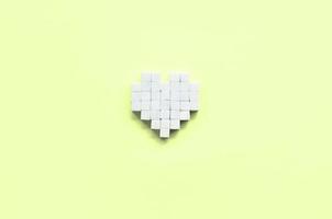 een hart gemaakt van suiker kubussen leugens Aan een modieus pastel limoen foto