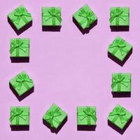 kader van veel klein groen geschenk dozen Aan structuur achtergrond van mode modieus pastel roze kleur papier foto