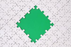 framing in de het formulier van een ruit, gemaakt van een wit decoupeerzaag puzzel in de omgeving van de groen ruimte foto