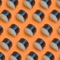 klassiek zwart sushi broodjes Aan helder oranje achtergrond foto