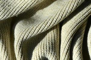 kleding stof structuur van een zacht geel gebreid trui. macro beeld van de structuur van bindingen in garens foto