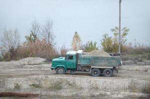 dump vrachtauto transporten zand en andere mineralen in de mijnbouw groeve. zwaar industrie foto