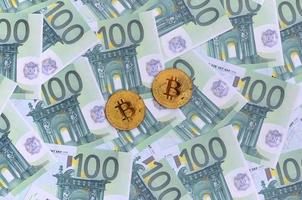 gouden fysiek bitcoins is leugens Aan een reeks van groen monetair denominaties van 100 euro. een veel van geld vormen een eindeloos hoop foto