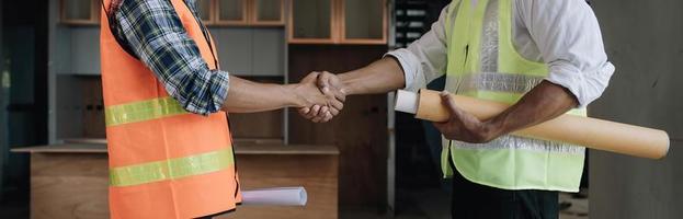 hand- in hand- tussen project aannemers en klanten ten gevolge naar onderhandeling van onkosten en investeringen, bouw en reparatie van woon- gebouwen. foto