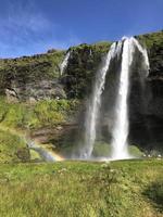 een regenboog in voorkant van seljalandsfoss waterval Aan de zuidelijk kust van IJsland Aan een zonnig dag foto