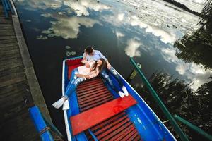 een paar rijden een blauw boot Aan een meer. romantiek. emotioneel paar. grappig en in liefde foto