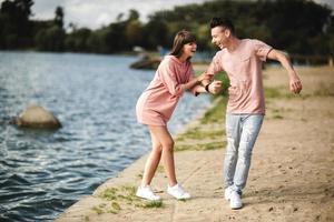 liefdevolle jonge paar zoenen en knuffelen in de buitenlucht. liefde en tederheid, dating, romantiek, familie, jubileumconcept. foto