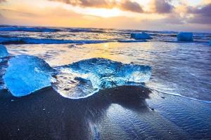 ijs rots met zwart zand strand Bij jokulsarlon strand, of diamant strand, in zuidoosten IJsland foto
