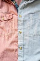 verschillend overhemden zijn dichtgeknoopt samen. kleding stof achtergrond in roze en grijs. plaats voor tekst. plat. foto