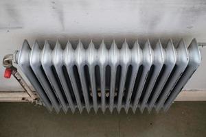 oud radiator met een klep dat bochten de verwarming Aan of uit. energie crisis concept. foto