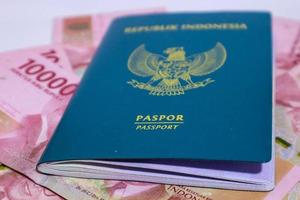 Indonesisch groen paspoort met een verzameling van honderd duizend roepia net zo de achtergrond. foto