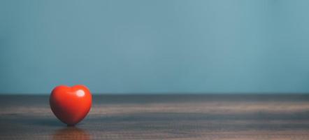 een rood hart voor liefde zetten Aan de tafel, Gezondheid zorg, orgaan bijdrage, wereld hart dag, wereld Gezondheid dag, opmerkzaamheid, goed het zijn, familie verzekering concept. foto