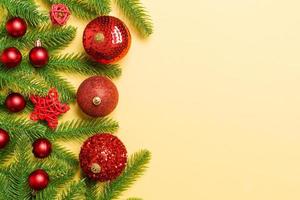 Kerstmis samenstelling gemaakt van Spar boom, ballen en verschillend decoraties Aan kleurrijk achtergrond. top visie van nieuw jaar komst concept met leeg ruimte voor uw ontwerp foto
