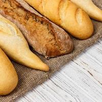 assortiment van vers Frans stokbrood Aan een houten tafel foto