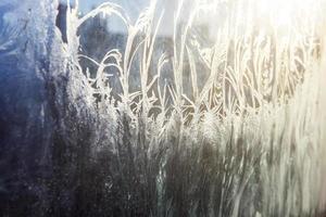 bevroren winter venster met glimmend ijs vorst patroon structuur foto