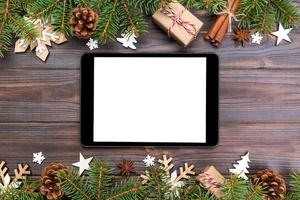 digitaal tablet bespotten omhoog met rustiek Kerstmis hout achtergrond decoraties voor app presentatie. top visie met kopiëren ruimte foto