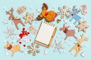 top visie van notitieboekje Aan blauw achtergrond gemaakt van vakantie decoraties en speelgoed. Kerstmis ornament concept foto