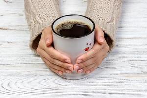 vrouw handen Holding kop met koffie, top visie foto