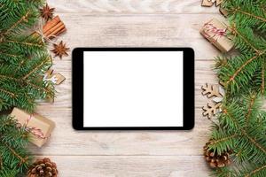 digitaal tablet bespotten omhoog met rustiek Kerstmis hout achtergrond decoraties voor app presentatie. top visie met kopiëren ruimte foto