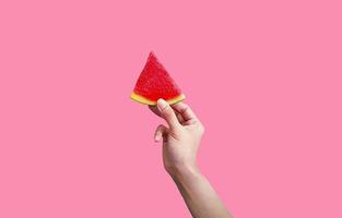 vrouw hand- Holding gesneden stuk van vers watermeloen geïsoleerd Aan roze achtergrond met knipsel pad en maken selectie. versheid fruit voor zomertijd en gezond aan het eten voedsel. heerlijk maaltijd, grappig foto