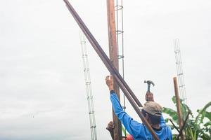 bouw arbeiders installeren houten ondersteunt voor meten bakstenen, bouwen buitenkant muren foto