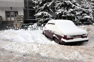 Charkov, Oekraïne - januari 4, 2022 een geparkeerd auto onder een dik laag van sneeuw. gevolgen van een sterk en niet verwacht sneeuwval in Oekraïne foto