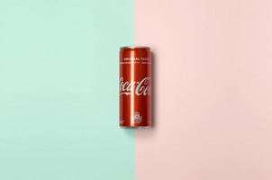 Charkov. Oekraïne - mei 2, 2022 vlak leggen schot single rood drinken blik kan coca cola houdende Aan pastel blauw en koraal achtergrond foto