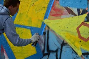 Charkov. Oekraïne - mei 2, 2022 festival van straat kunsten. jong jongens trek graffiti Aan een oud beton muren in de centrum van de stad. de werkwijze van schilderij Aan muren met aërosol verstuiven blikjes foto