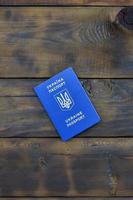 foto van de oekraïens buitenlands paspoort, aan het liegen Aan een donker houten oppervlak. de concept van introduceren visumvrij reizen voor oekraïens burgers