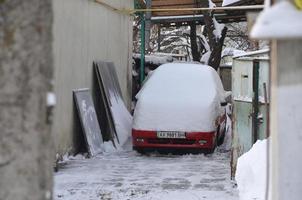 Charkov, Oekraïne - januari 4, 2022 een geparkeerd auto onder een dik laag van sneeuw. gevolgen van een sterk en niet verwacht sneeuwval in Oekraïne foto