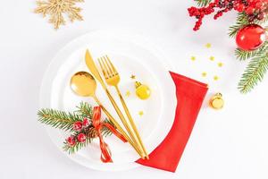 mooi feestelijk instelling van de nieuw jaar tafel. wit platen, een goud reeks van bestek, ballen, sneeuwvlokken, een net Afdeling. top visie. foto