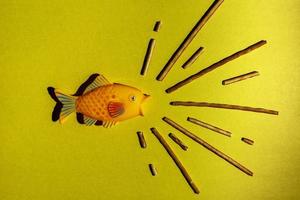 een creatief samenstelling van schreeuwen vis, een minimalistisch concept, Aan een geel achtergrond foto