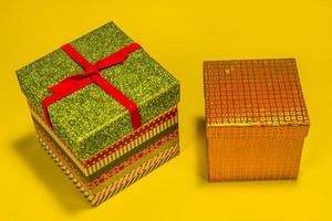 twee decoratief Kerstmis geschenk dozen Aan geel achtergrond foto
