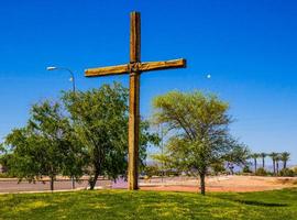 religieus kruis Aan met gras begroeid heuveltje foto