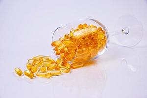 vis olie capsules. geel omega 3 pillen in pot Aan de wit. vis olie capsules in glas . in kan. in emmer ampullen foto