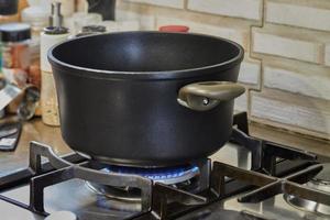 pot met Koken voedsel in de keuken Aan gas- fornuis foto