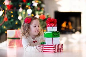 klein meisje cadeautjes openen op kerstochtend foto